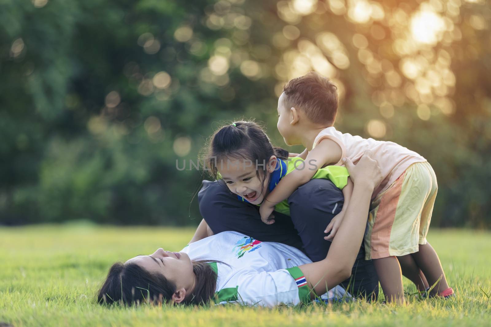 Happy family playing in the park. Mother and son play together in nature in the summer