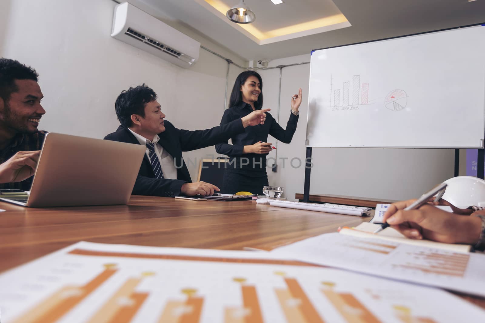 Business people are brainstorming to plan their business operations. Asian business woman leader presenting work to mixed race colleagues in the meeting