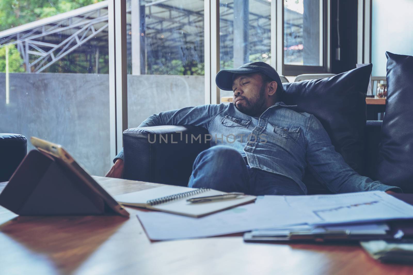 Workaholic businessman sleeping on on the sofa after a stressing by numberone9018