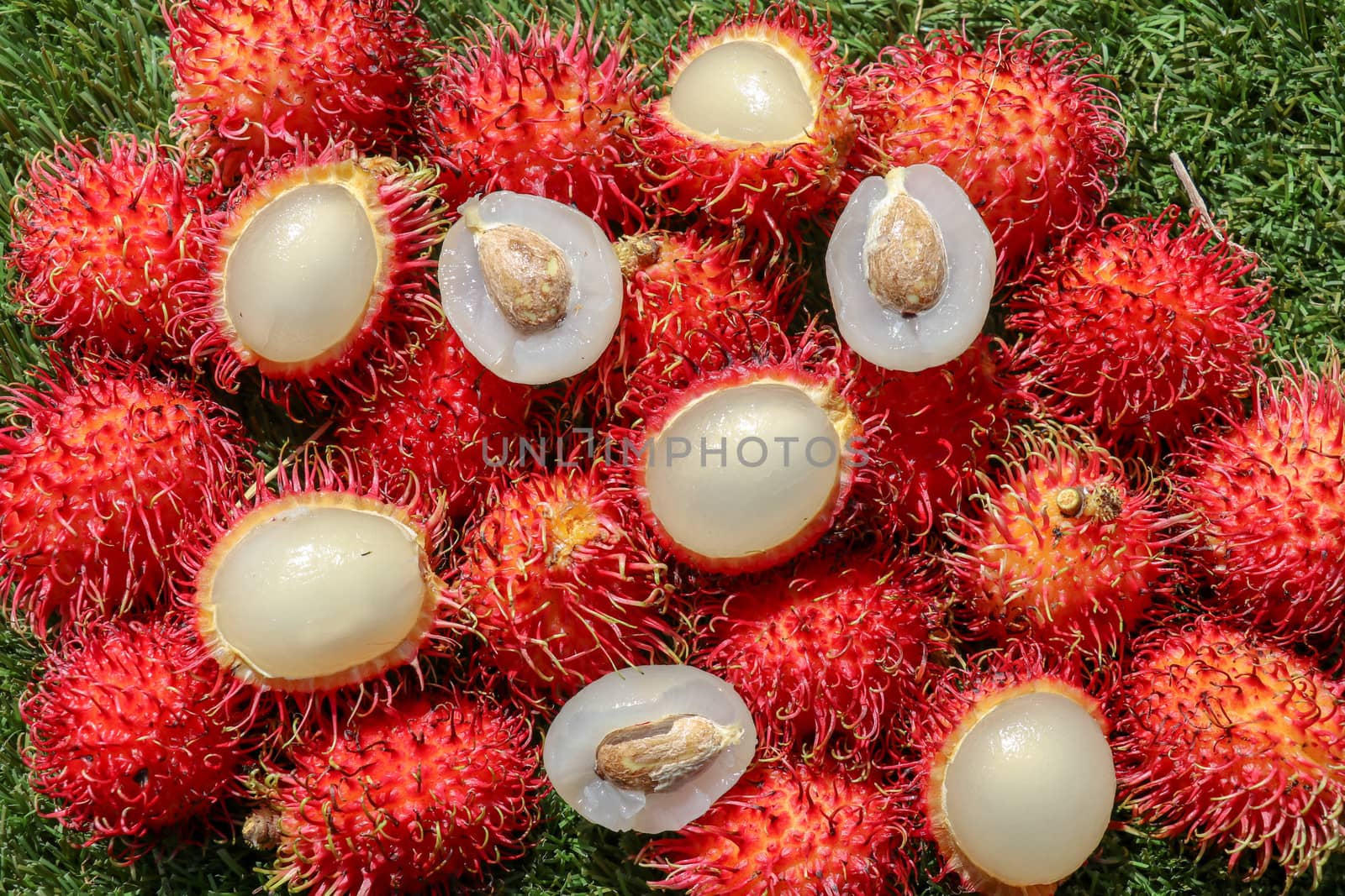 Full frame shoot of bunch of red rambutan fruits. Close up Rambutan peeled. Top view healthy fruits rambutans. The sweet fruit is a round to oval single-seeded berry covered with fleshy pliable spines