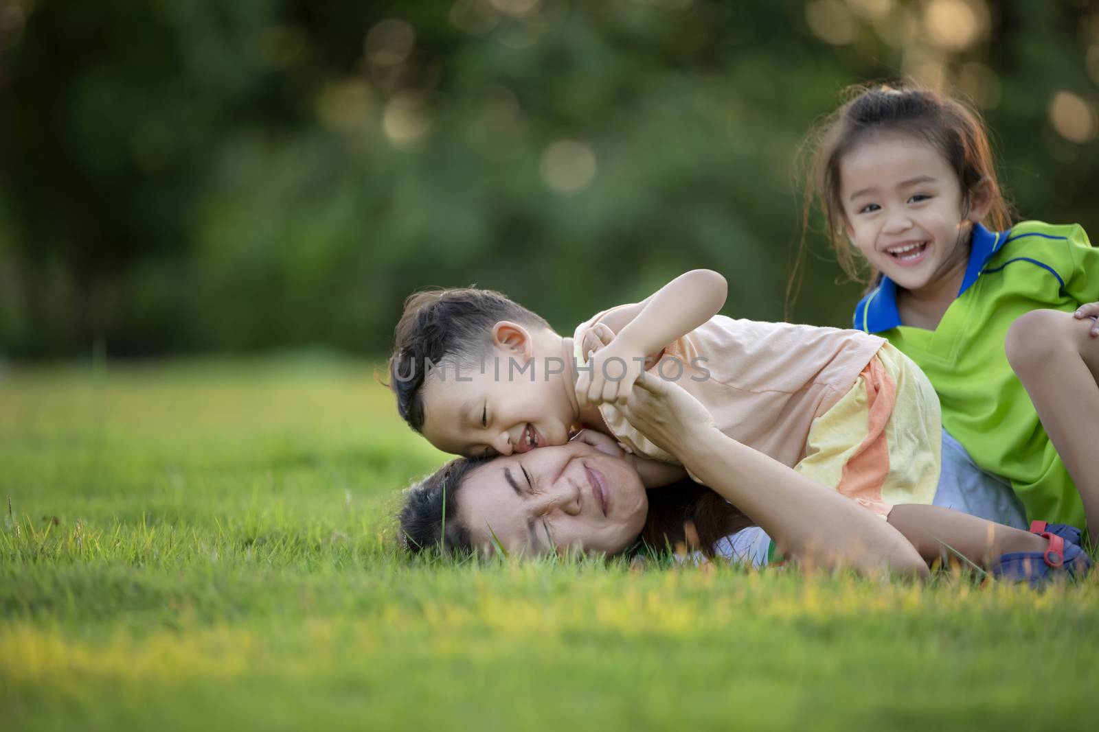 Happy family playing in the park. Mother and son play together in nature in the summer