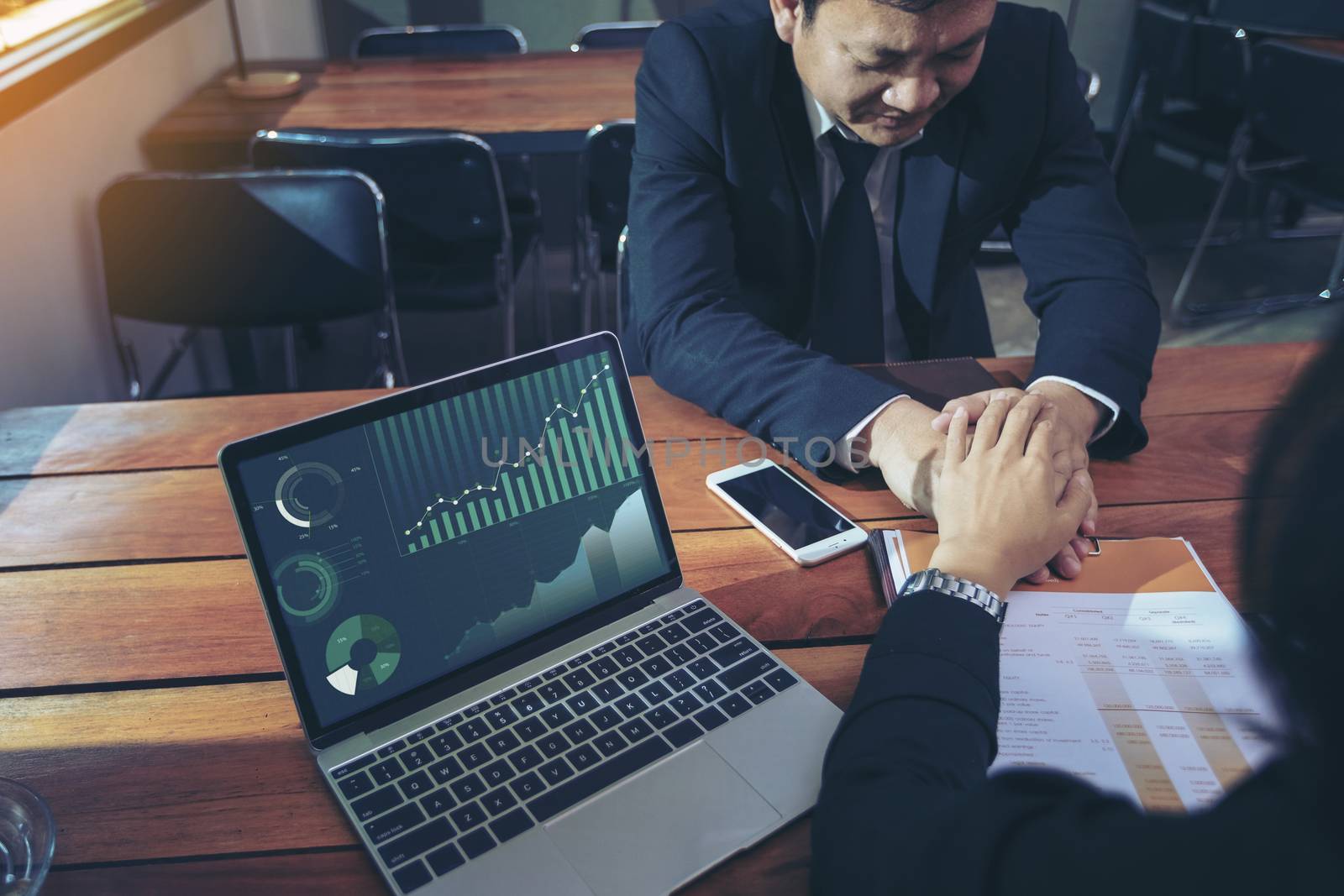 Beautiful young business man holding hands to encourage male investors unsuccessful investment. Stressed depressed business person.