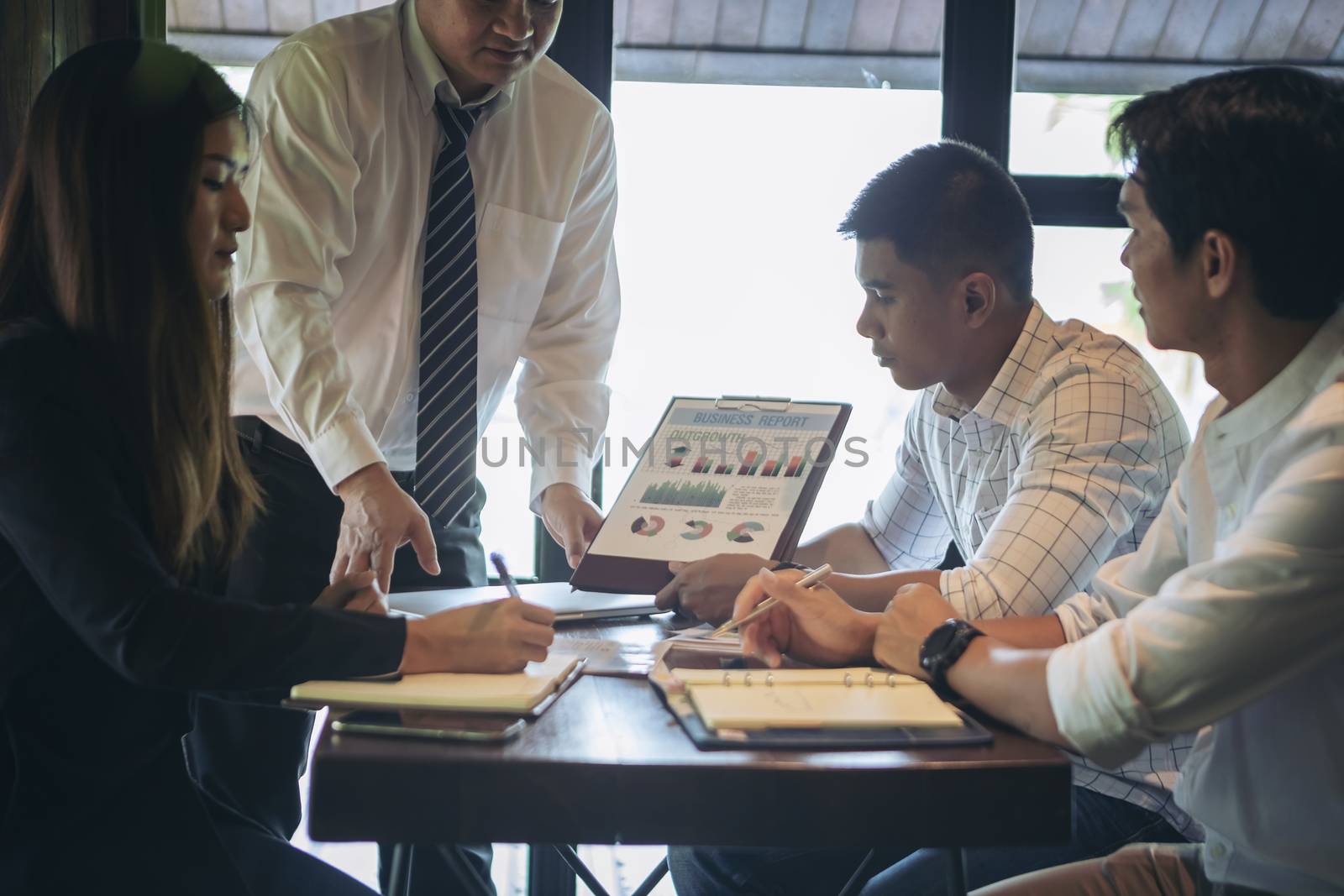 Successful businessman boss presenting new project to employees, businessman giving presentation to clients in meeting room, team leader reporting about work explaining result on flipchart. 