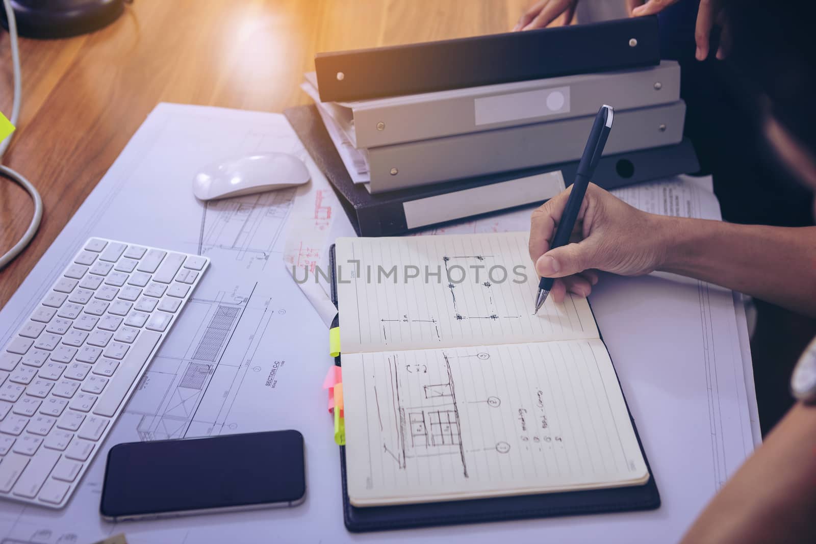 Male manager putting his ideas and writing business plan at workplace,man holding pens and papers, making notes in documents, on the table in office. selective focus.