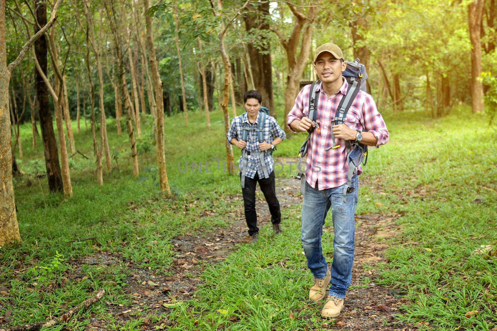 Two handsome man is touring in the woods during the holidays. Hiker walking in the forest. Autumn, nature, people concept