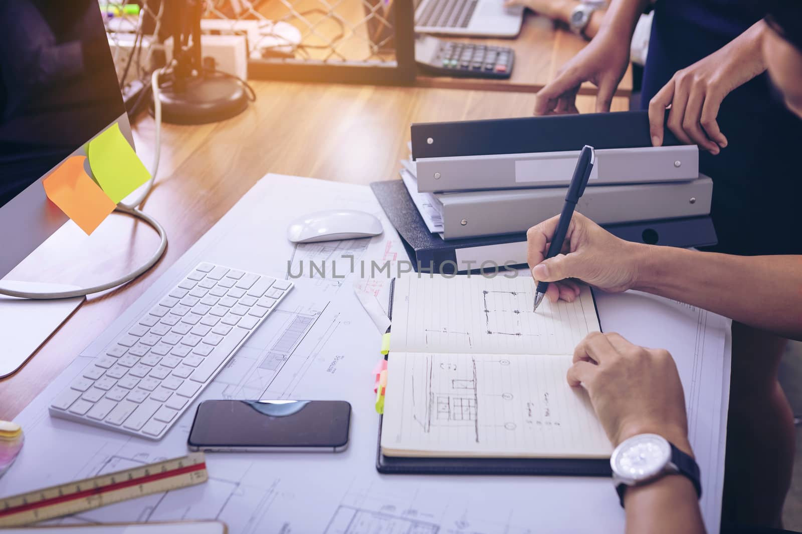 Male manager putting his ideas and writing business plan at workplace,man holding pens and papers, making notes in documents, on the table in office. selective focus.