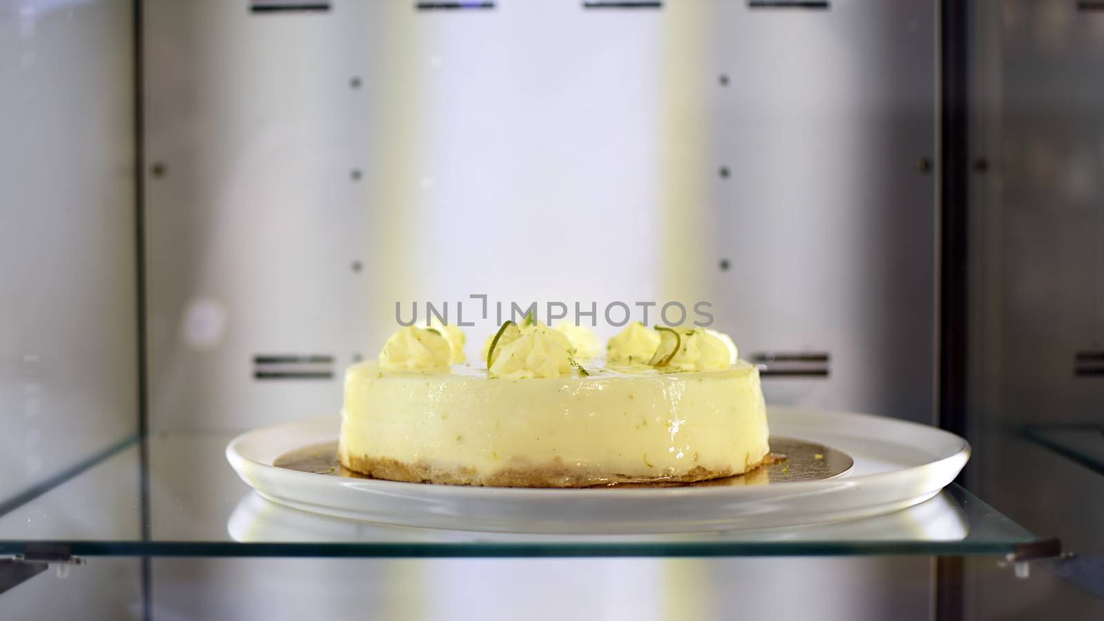 Delicious cheese-cake with whipped cream at bakery display.