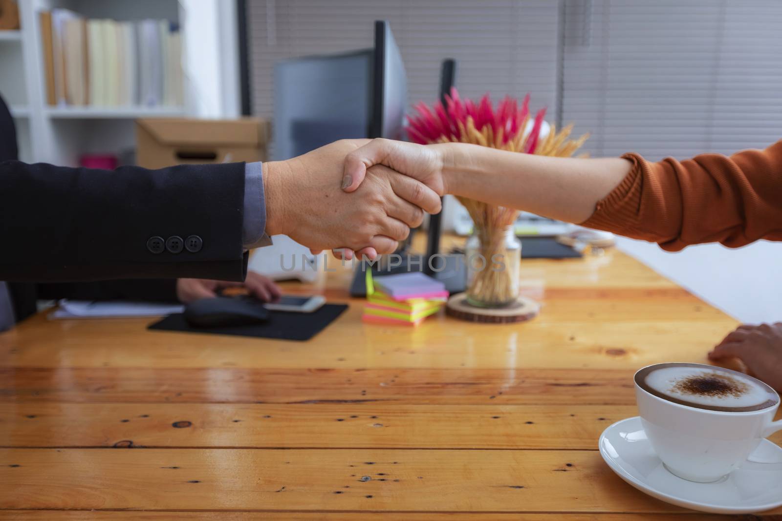 Businesspeople and partners shaking hands over the table, mainta by numberone9018