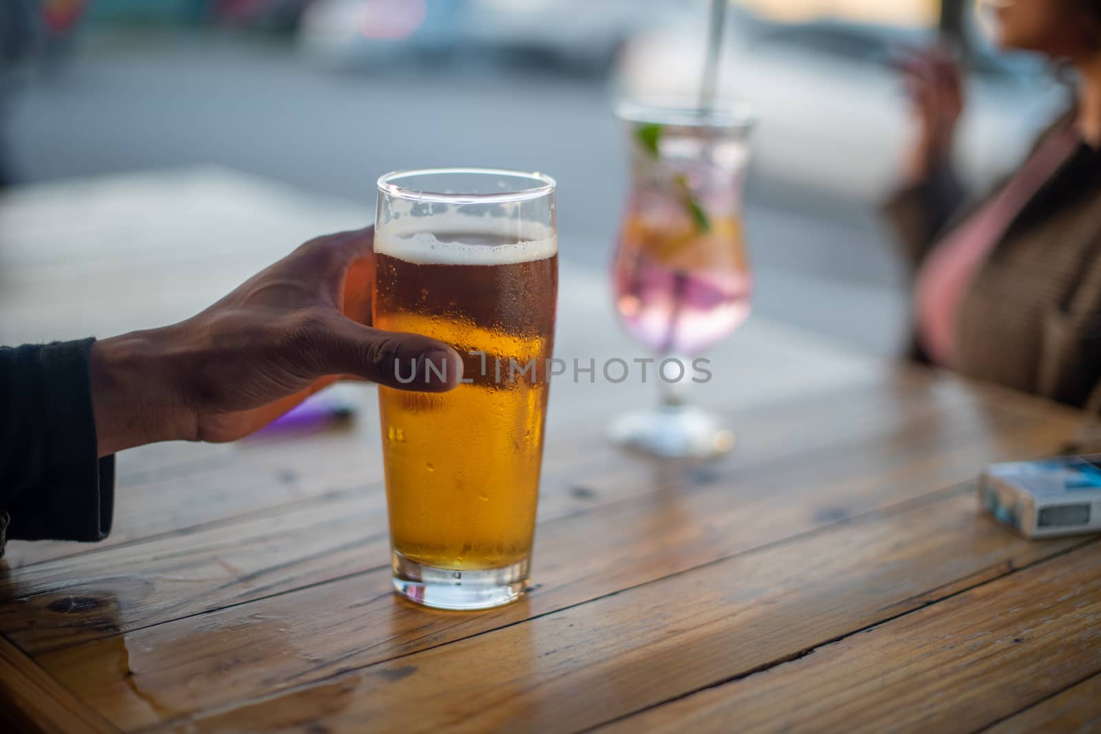 Close up shot of hand holding glass of beer