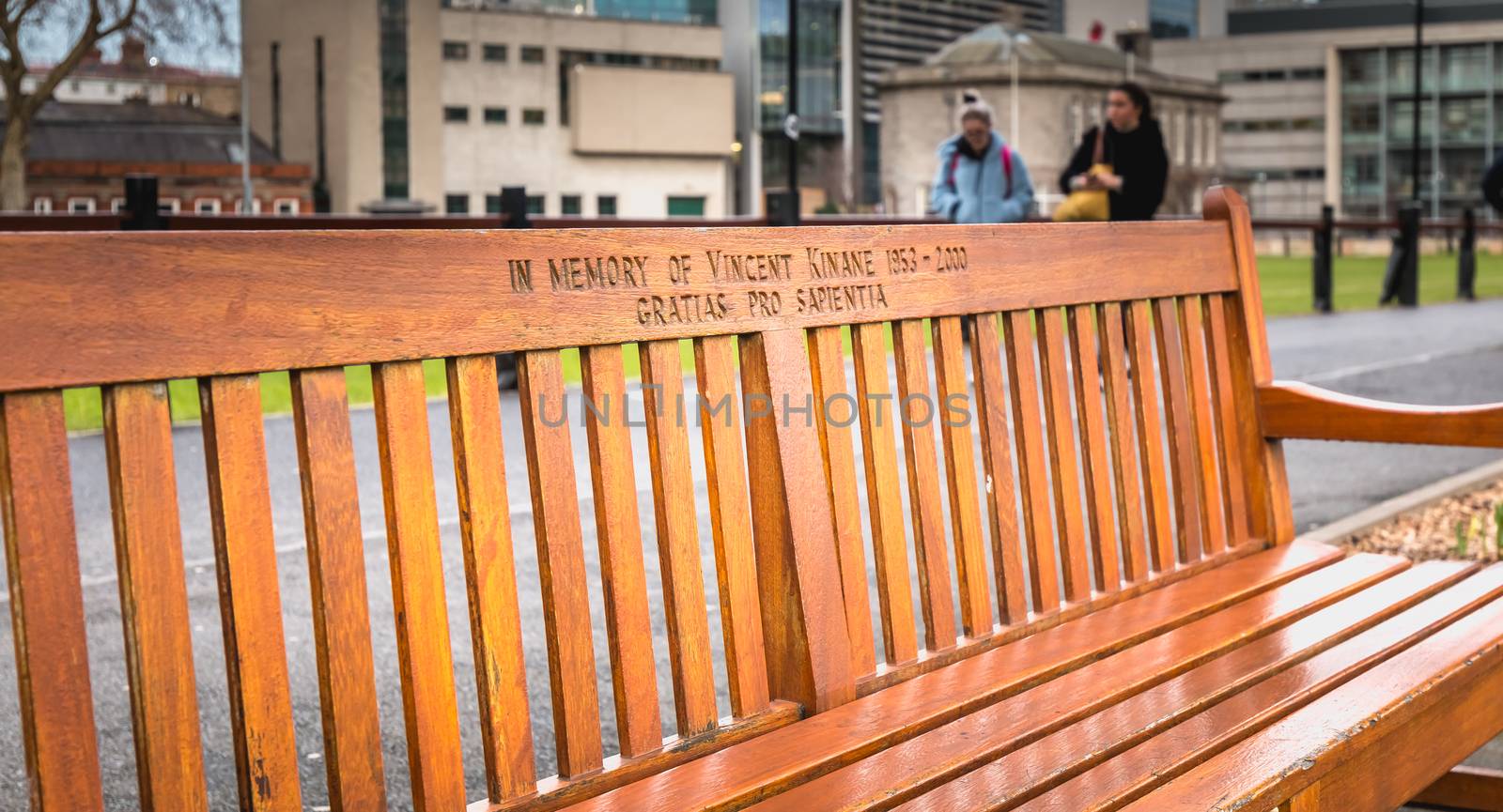 Dublin, Ireland - 11 February 2019: Wooden bench where it is written In memory of Vincent Kinane 1953 - 2000 in the city center on a winter day