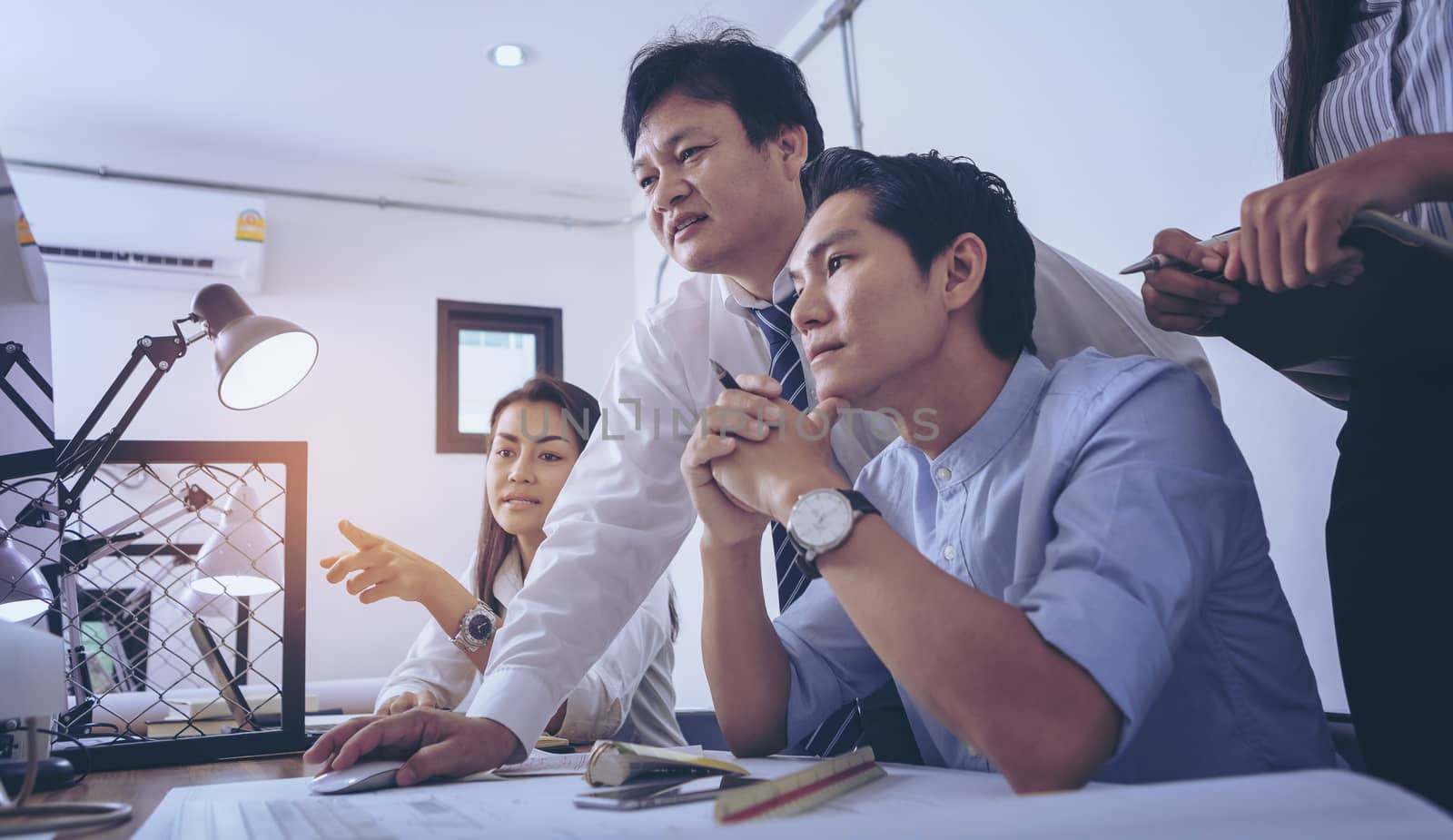 Businessman giving presentation on  computer screen to colleagues in office. Business meeting time. Idea presentation, analyze plans.