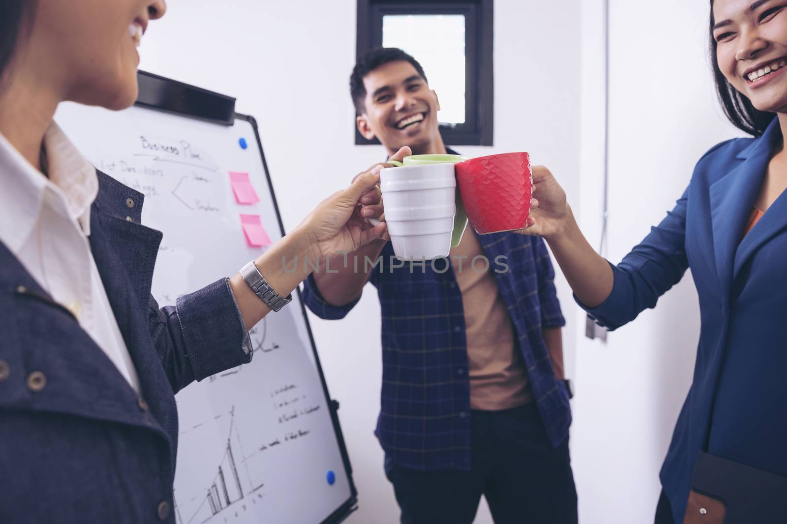 Young business people are celebrating with coffee after a successful presentation of the meeting with customers.