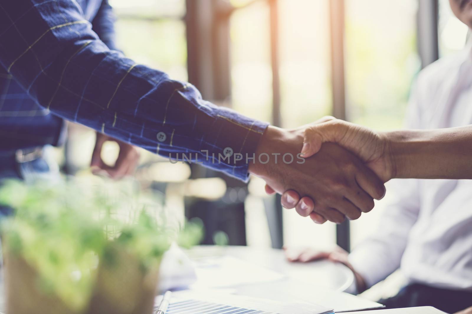 Businessmen negotiate in a coffee shop. Hold hands and greet before the business talks comfortably.