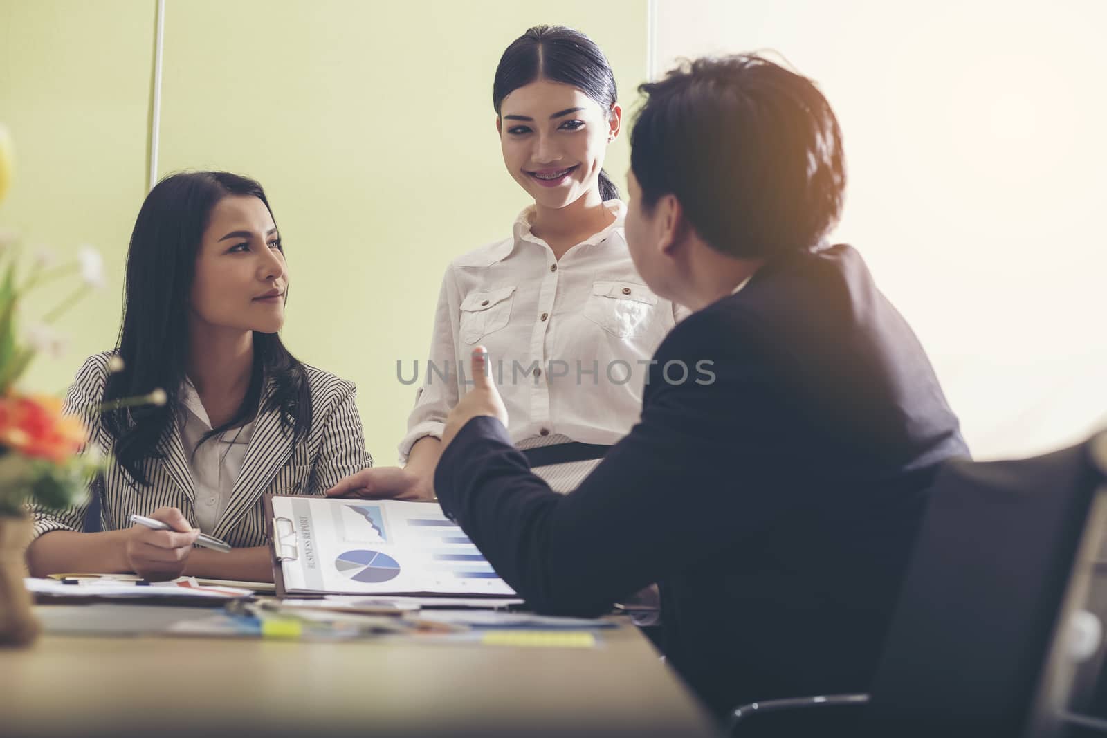 Creative business partners discussing documents at meeting happily