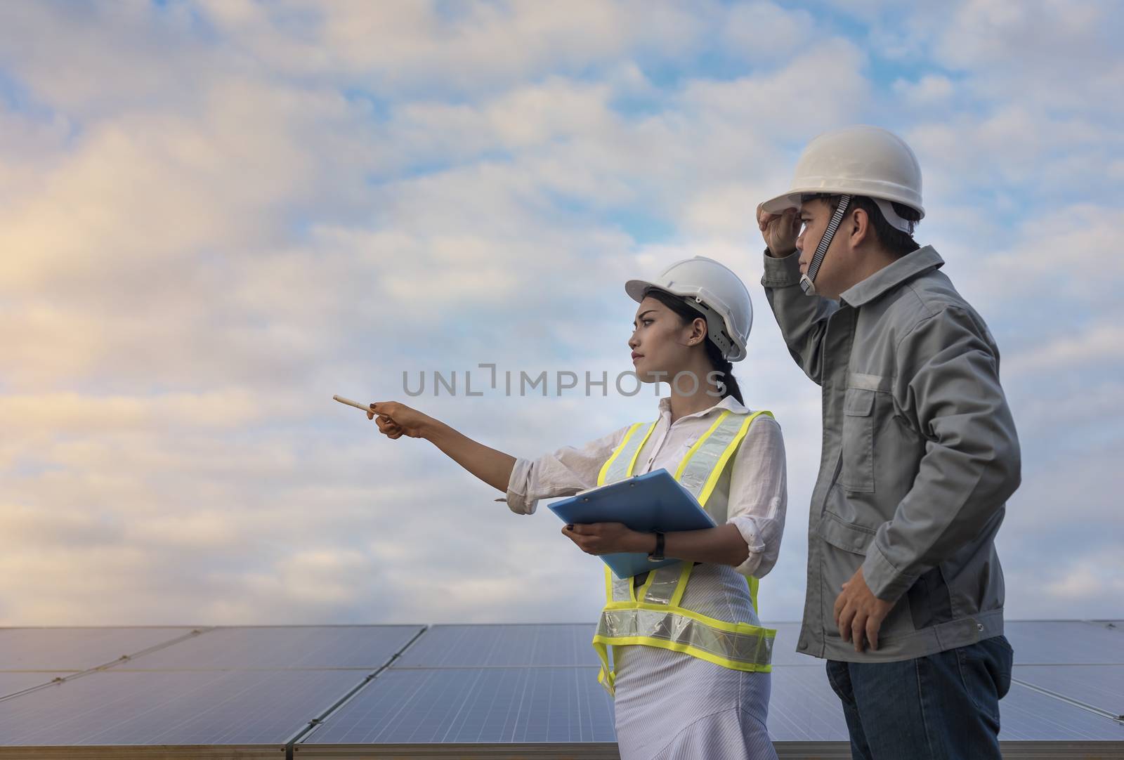 solar engineer and electrician checking and resolve problem solar panels to produce electricity.