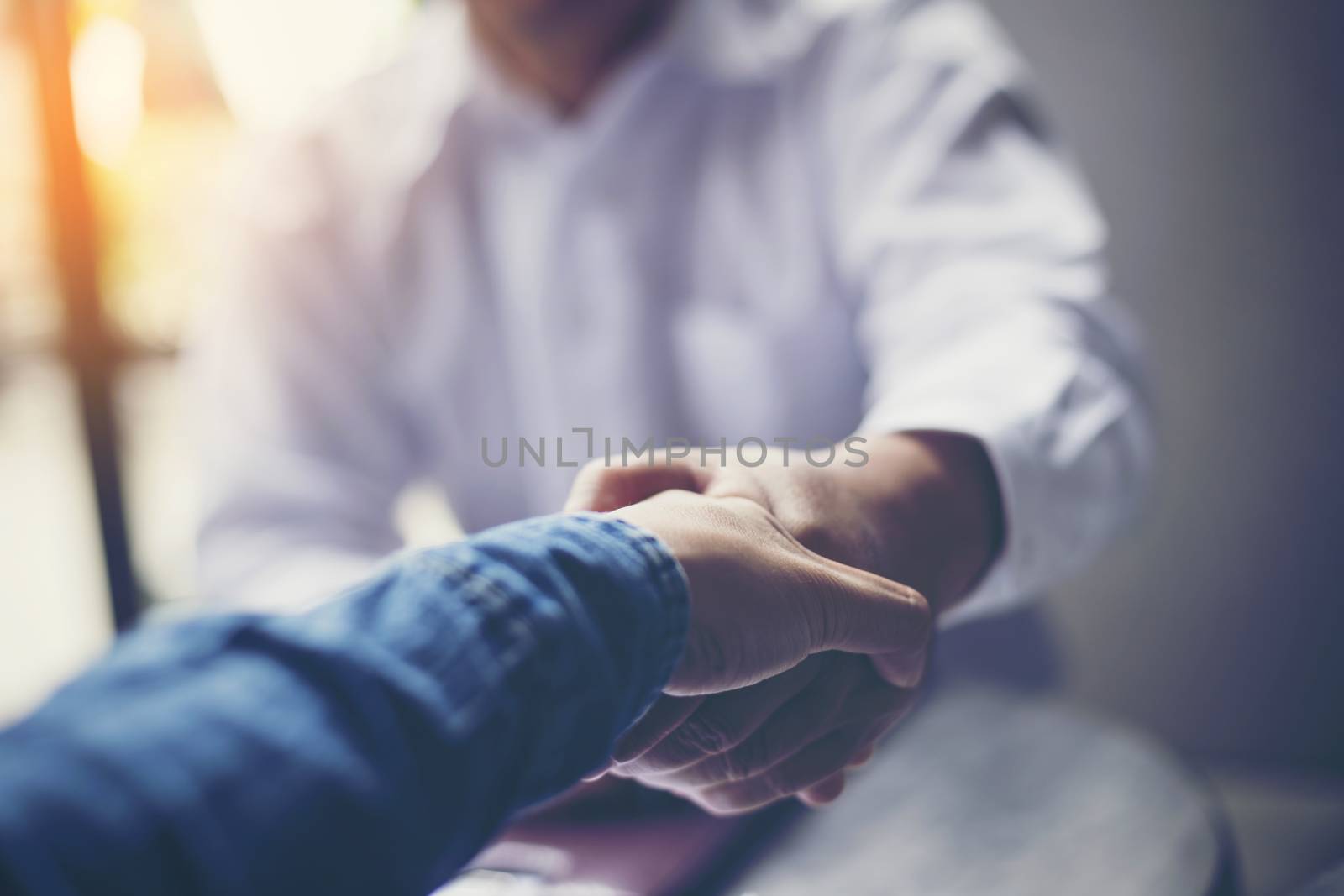 Businessmen negotiate in a coffee shop. Hold hands and greet before the business talks comfortably