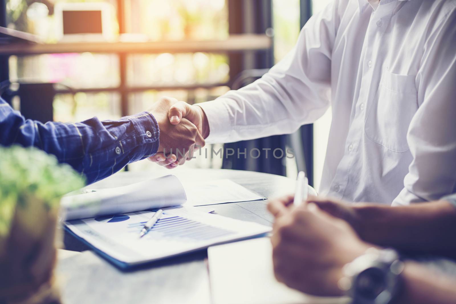 Businessmen negotiate in a coffee shop. Hold hands and greet before the business talks comfortably