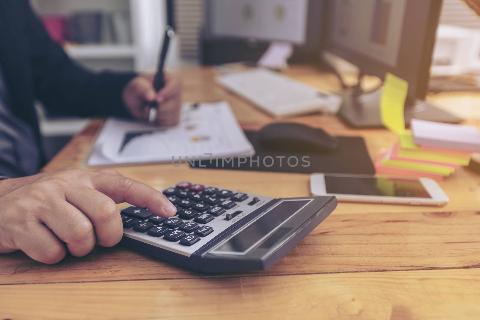 closeup of a young man checking accounts with a calculator by numberone9018