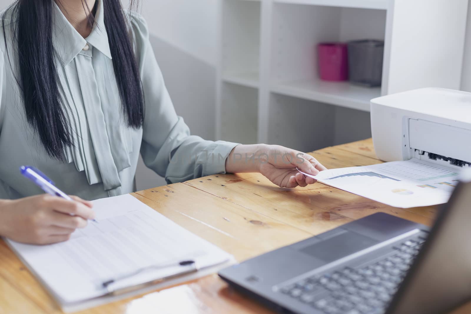 Beautiful young businesswoman doing some paperwork while sitting by numberone9018