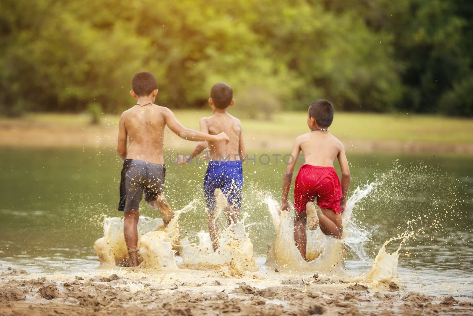 Asian children are playing in the river joyfully. by numberone9018