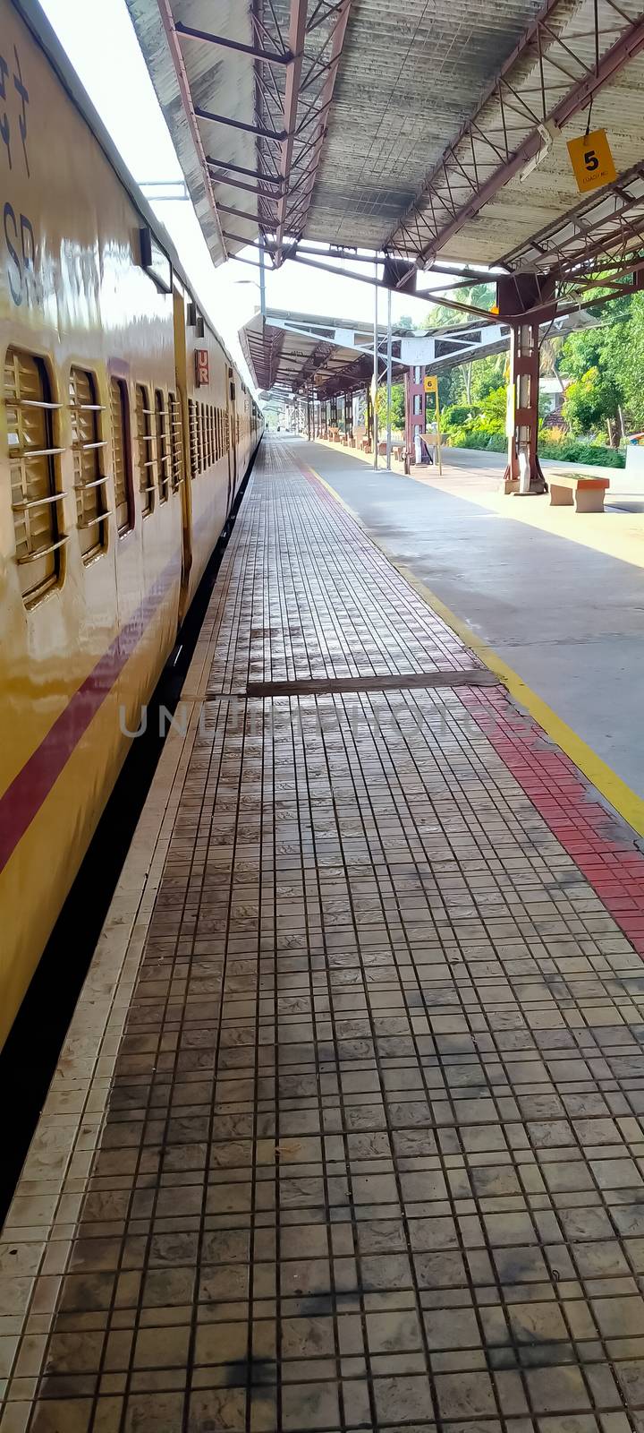 Guruvayur, Kerala, INDIA - March 15: Empty platform under a shed and a train at the railway station on March 15, 2020 in Guruvayur, India.