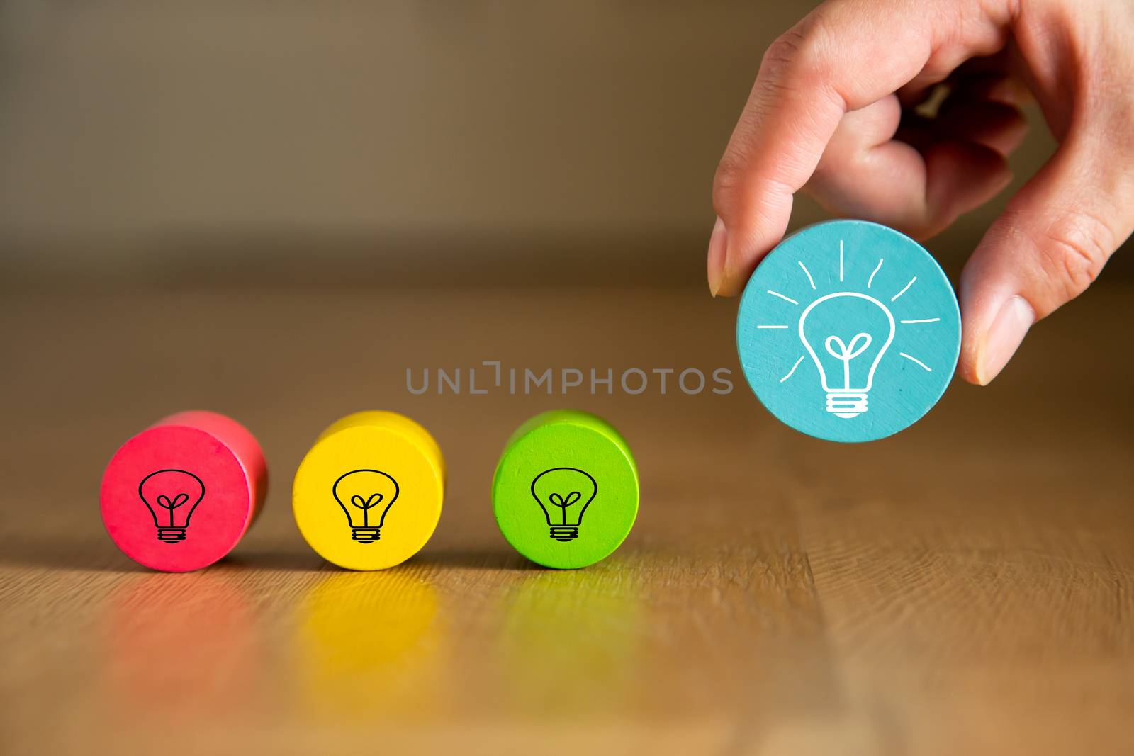 Concept creative idea and innovation. Hand picking up a wooden cube block with light bulb icon