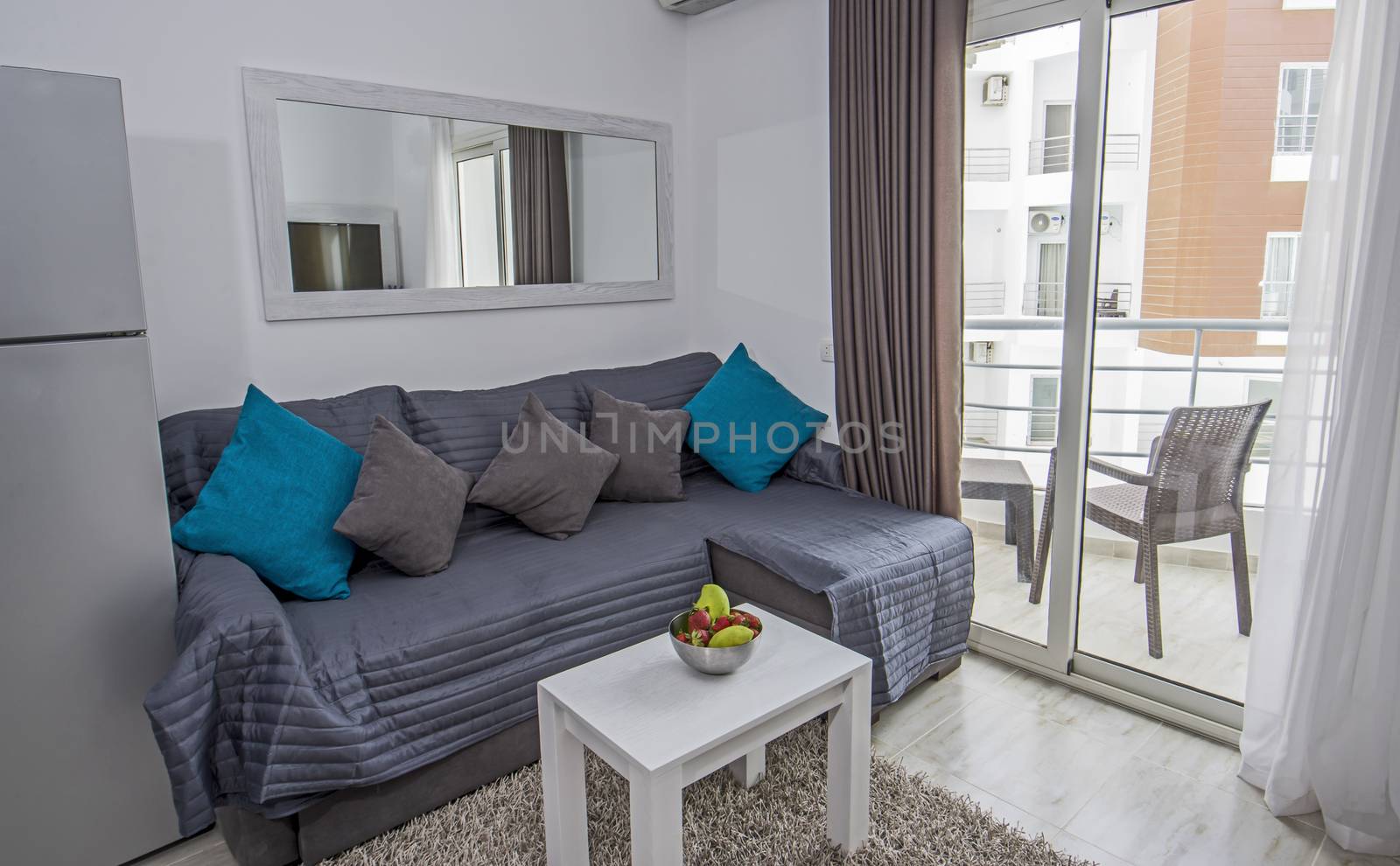 Living room lounge in luxury studio apartment show home with balcony showing interior design decor furnishing