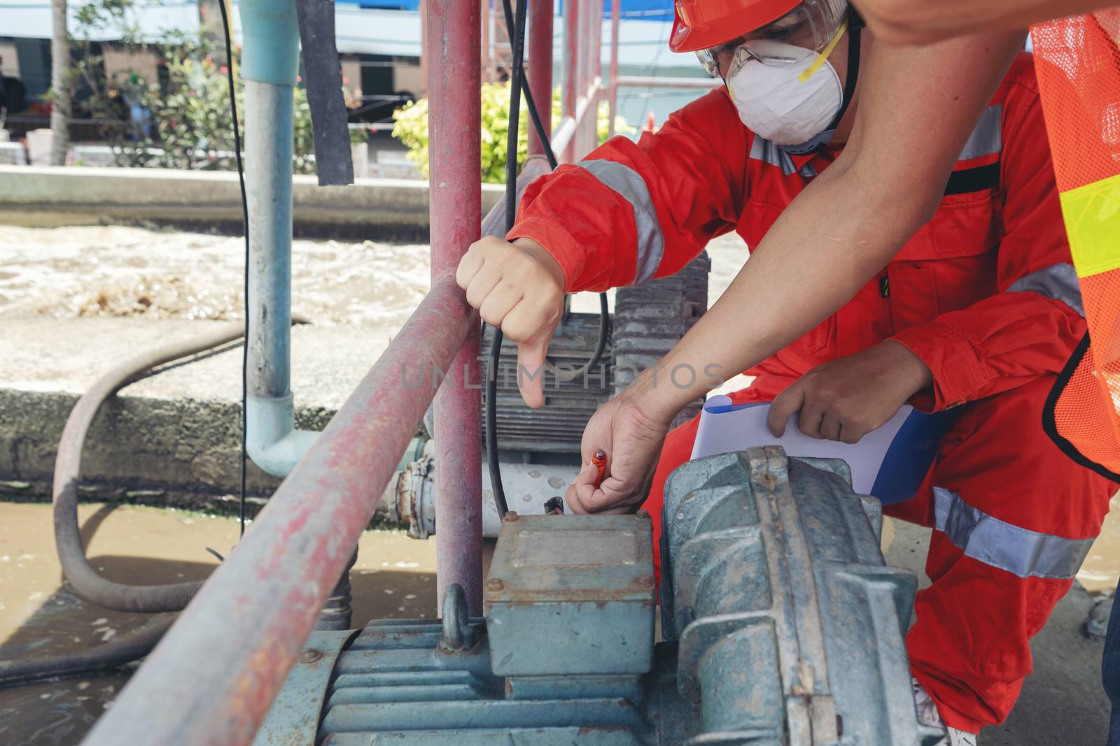 The maintenance technician is inspecting the wastewater treatment equipment of the treatment plant so that it can be operated at all times.