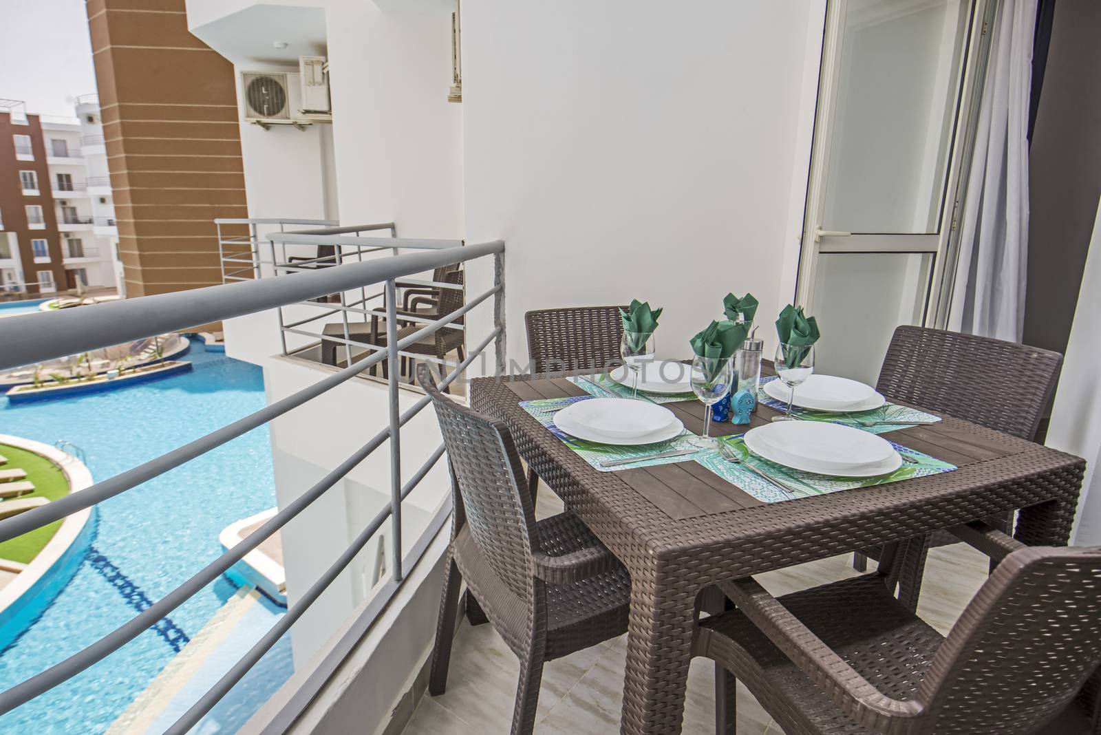 Terrace furniture of a luxury apartment in tropical resort with plastic furniture and pool view