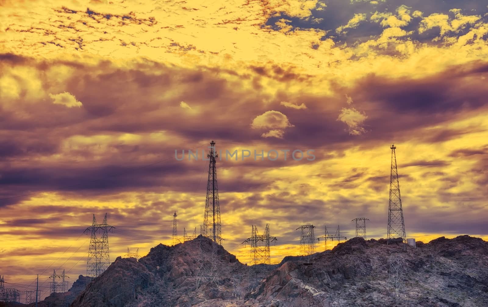 High voltage electric tower at sunset. Storm clouds in the sky.