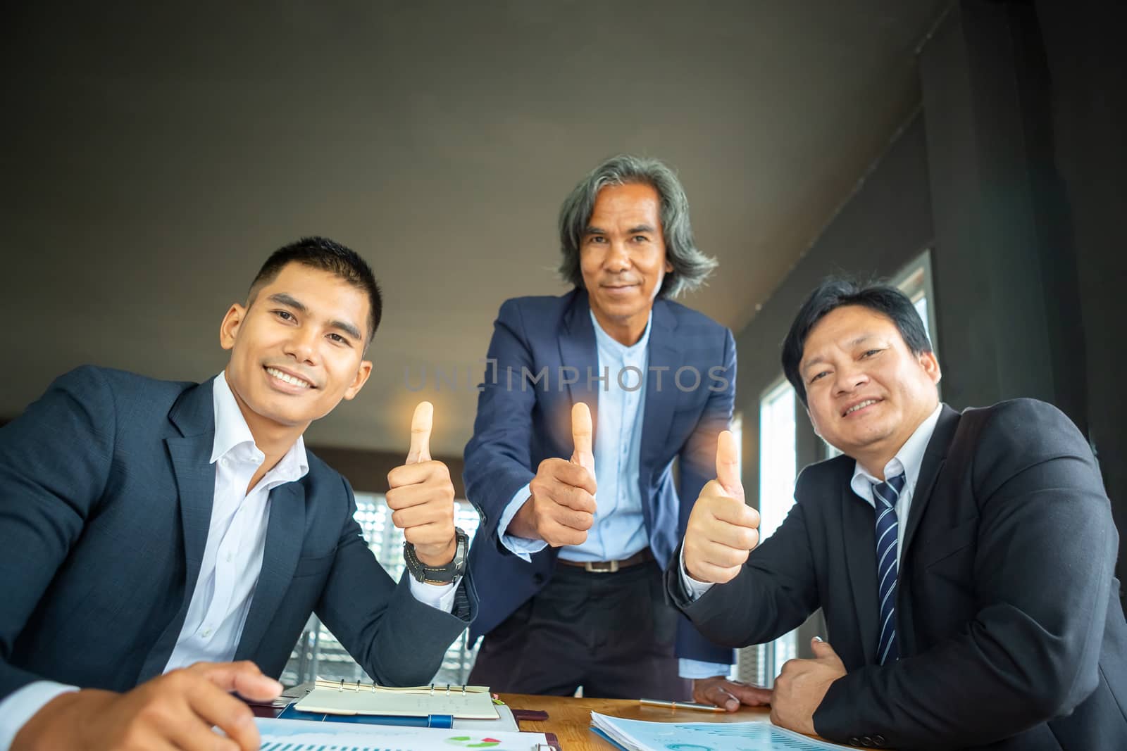 The three businessmen who thumbs up indicate the success of their business operations. Teamwork concept for development and success