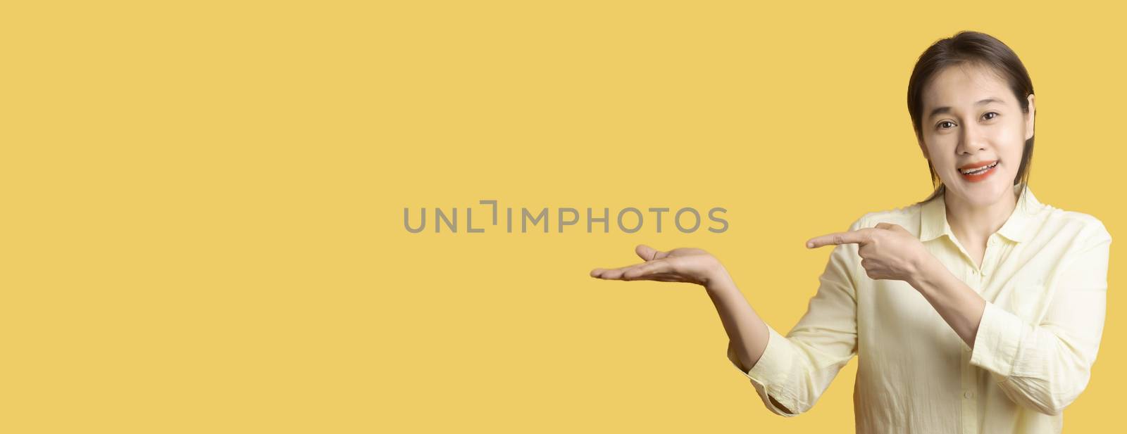 Beatuful asia women's hand Two hands One hand pointing the other hand Open hands on yello background with copy space. Human hand with copy space. for product or advertising .