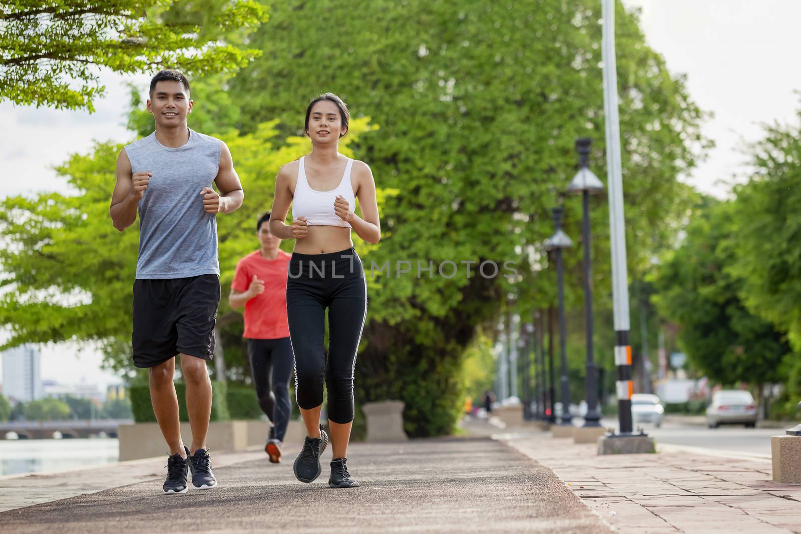 Couples who take care of their health by exercising happily in the city. Health care concept