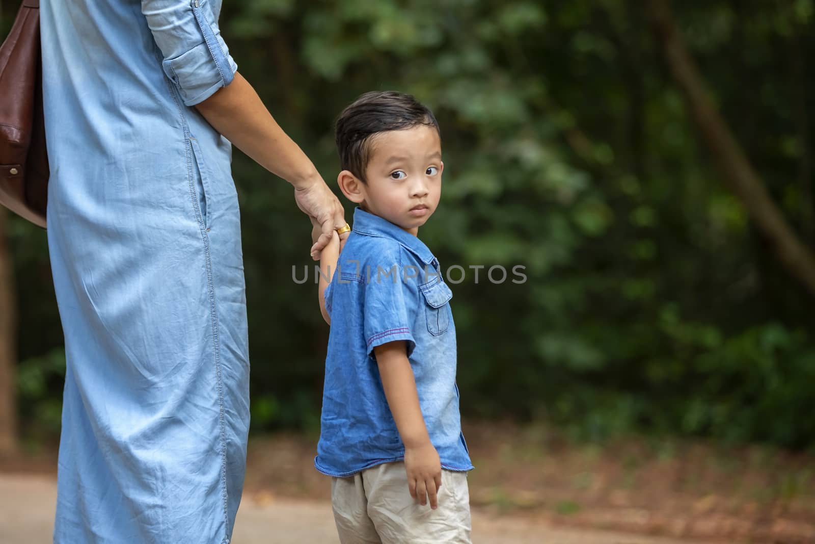 Happy mother and adorable little boy enjoying warm weather at beautiful park