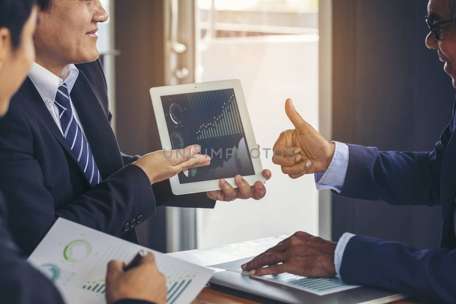 Image of business people hands working with papers at meeting. Businessman holding pens and holding graph paper are meeting to plan sales to meet targets set in next year.