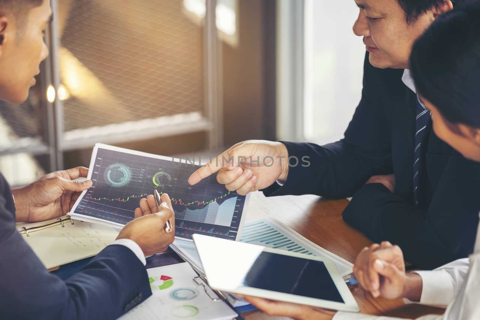 Image of business people hands working with papers at meeting. Businessman holding pens and holding graph paper are meeting to plan sales to meet targets set in next year.