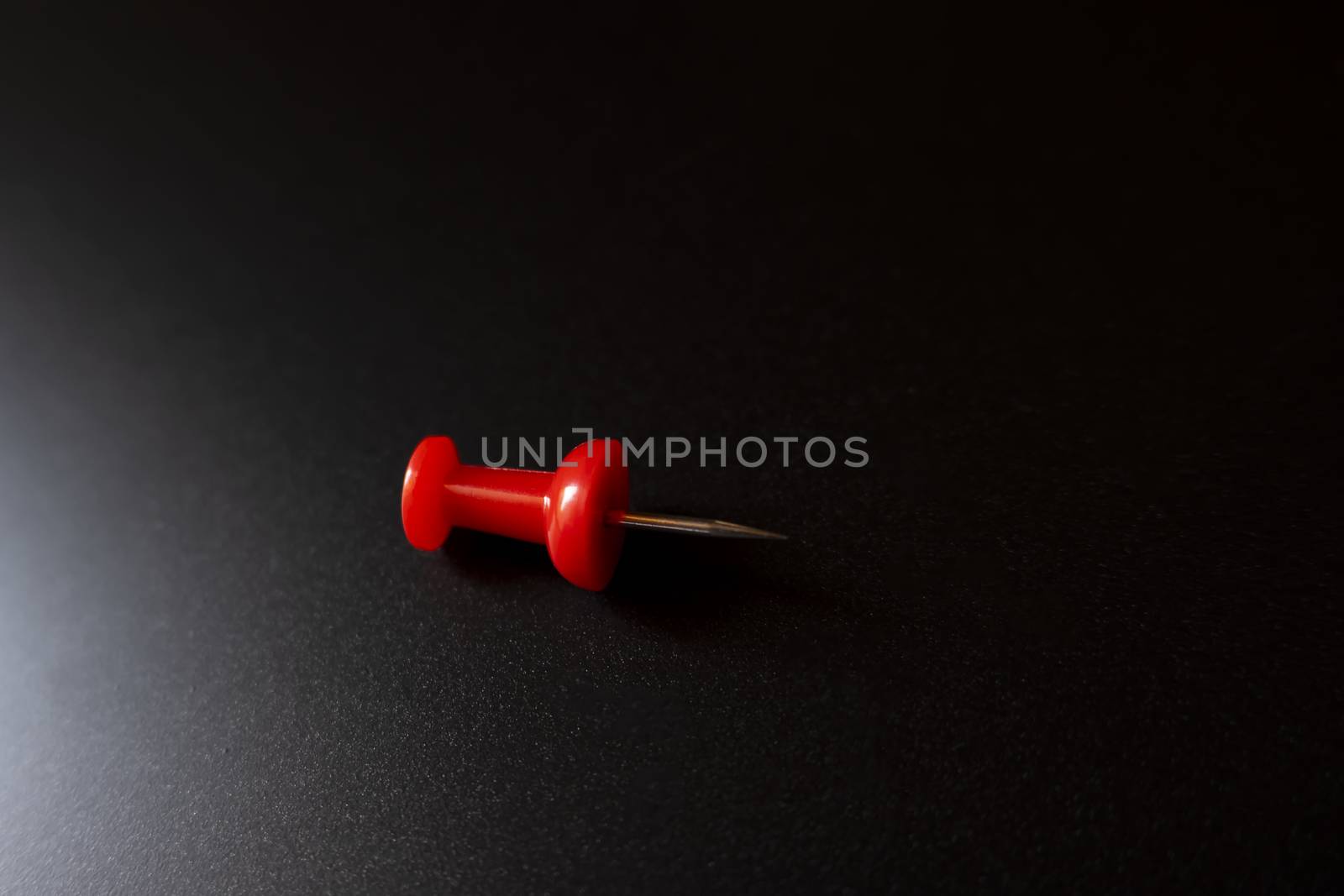 Closeup shot of a single plastic handled red pushpin by mahesh_2020