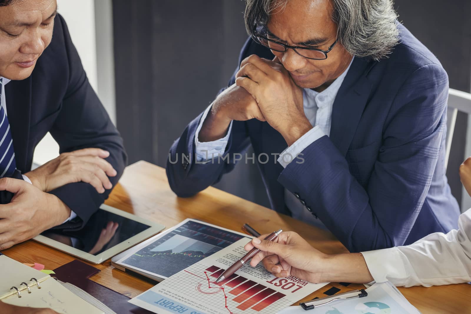 Image of business people hands working with papers at meeting. Businessman holding pens and holding graph paper are meeting to plan sales to meet targets set in next year.