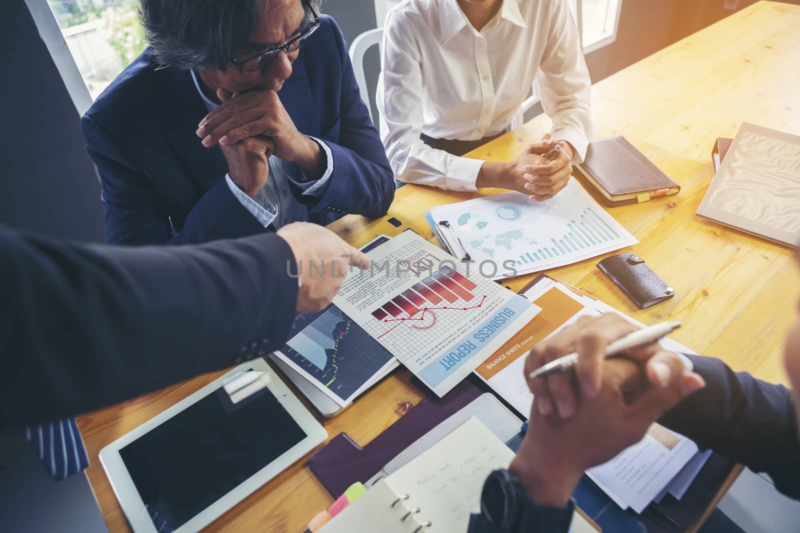 Image of business people hands working with papers at meeting. Businessman holding pens and holding graph paper are meeting to plan sales to meet targets set in next year.