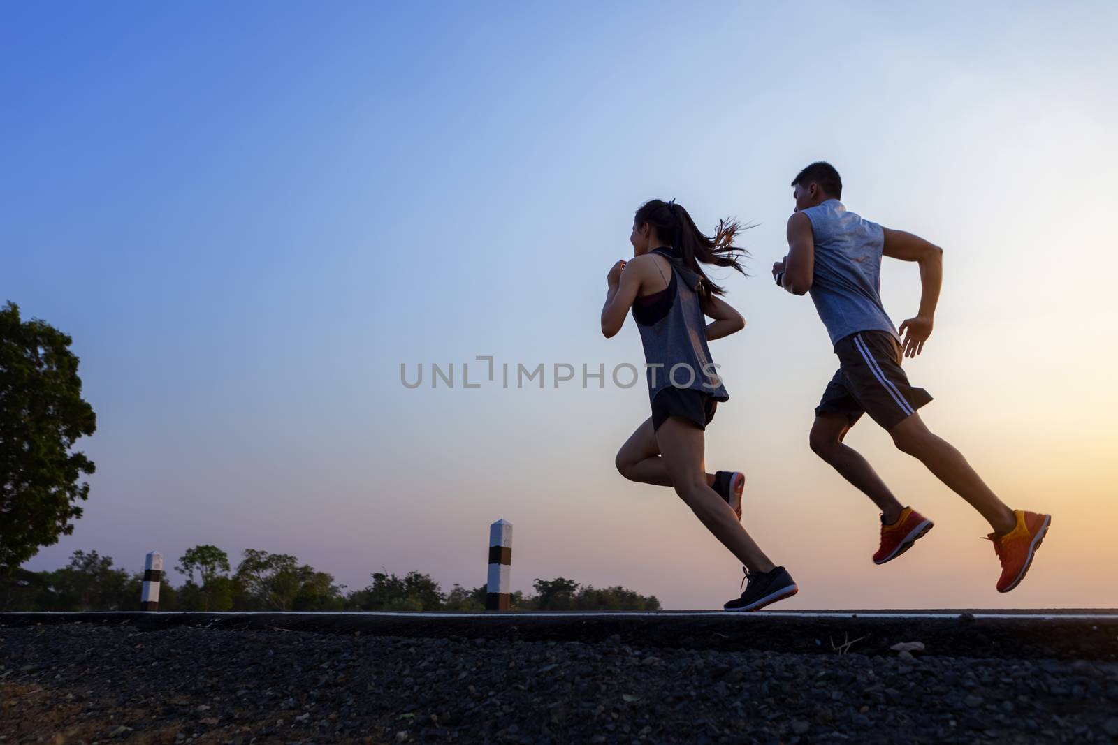 Running at sunrise couple exercising for marathon and workout 
fitness, sport, people and lifestyle concept - Happy couples exercising with outdoor running