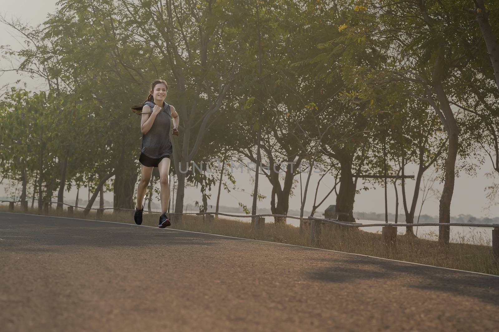 young woman runner running on road. healthy lifestyle young fitness woman running