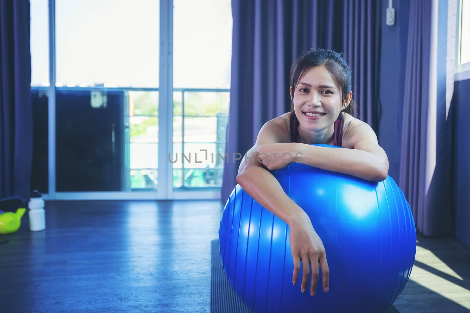 Beautiful woman is exercising by playing Pilates ball happily in by numberone9018