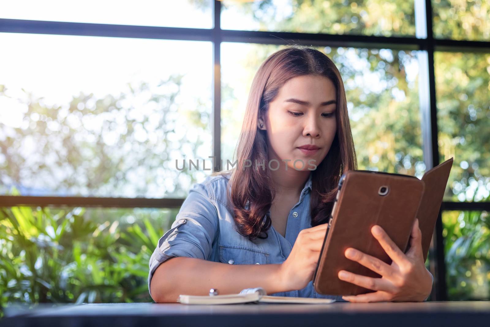 Beautiful Asian businesswoman who uses a tablet in the coffee sh by numberone9018