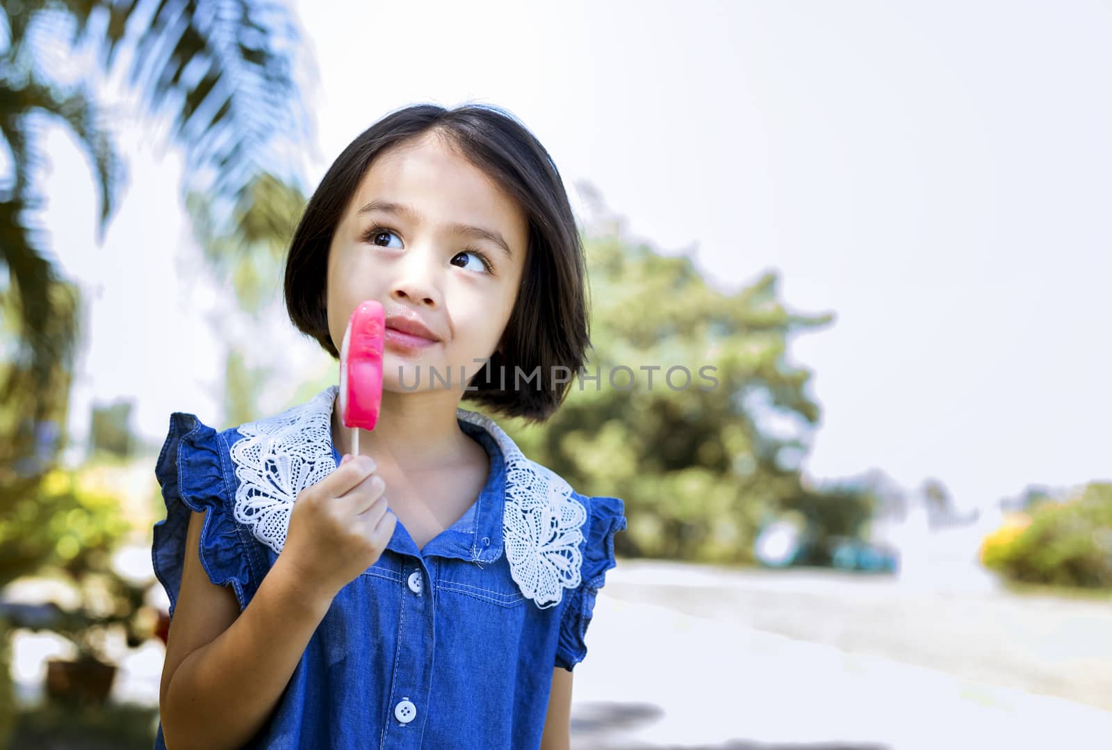 Cute little girl eating popsicle with sunset background by numberone9018