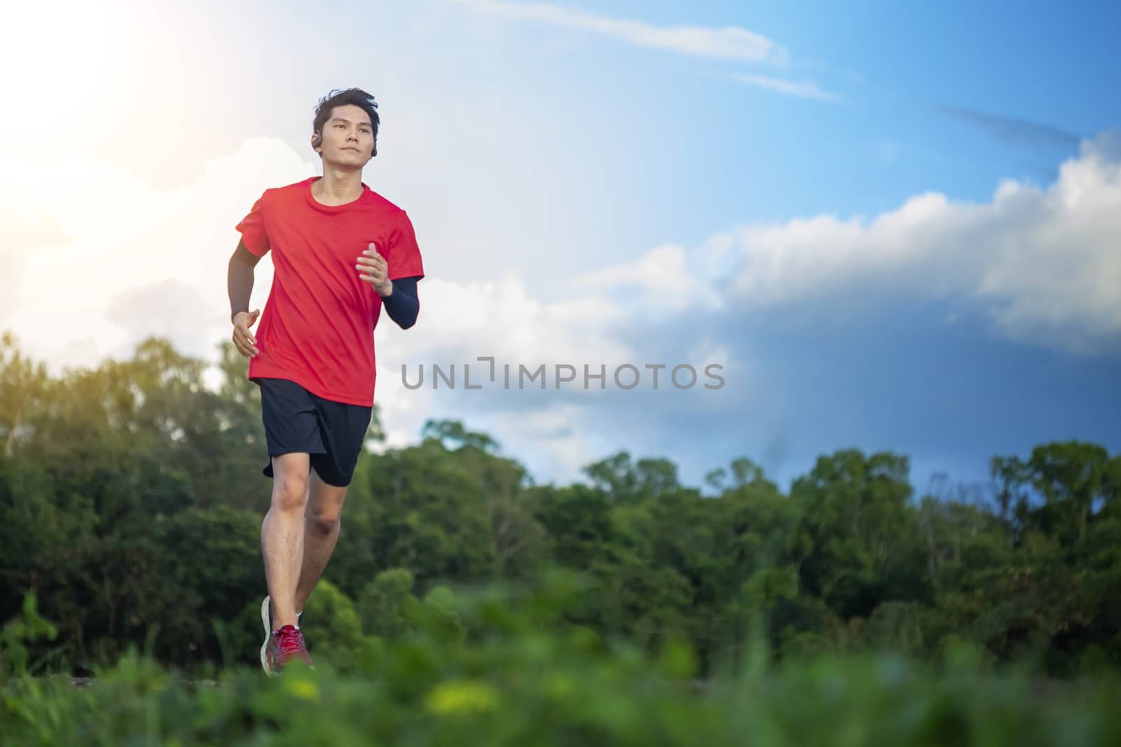 Handsome young man runs for good health on a rural road that is  by numberone9018