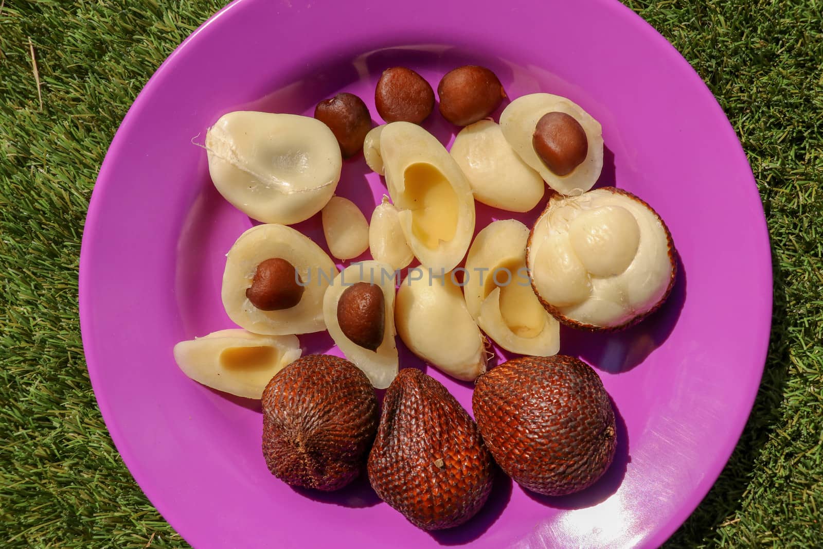 Close up of peeled, cuted and whole pieces of Snake fruit with seed. Top view of healthy fruit. Salak pondoh is one of the salak cultivars that mostly grows in Bali. Macro photo of Sweet Salacca.