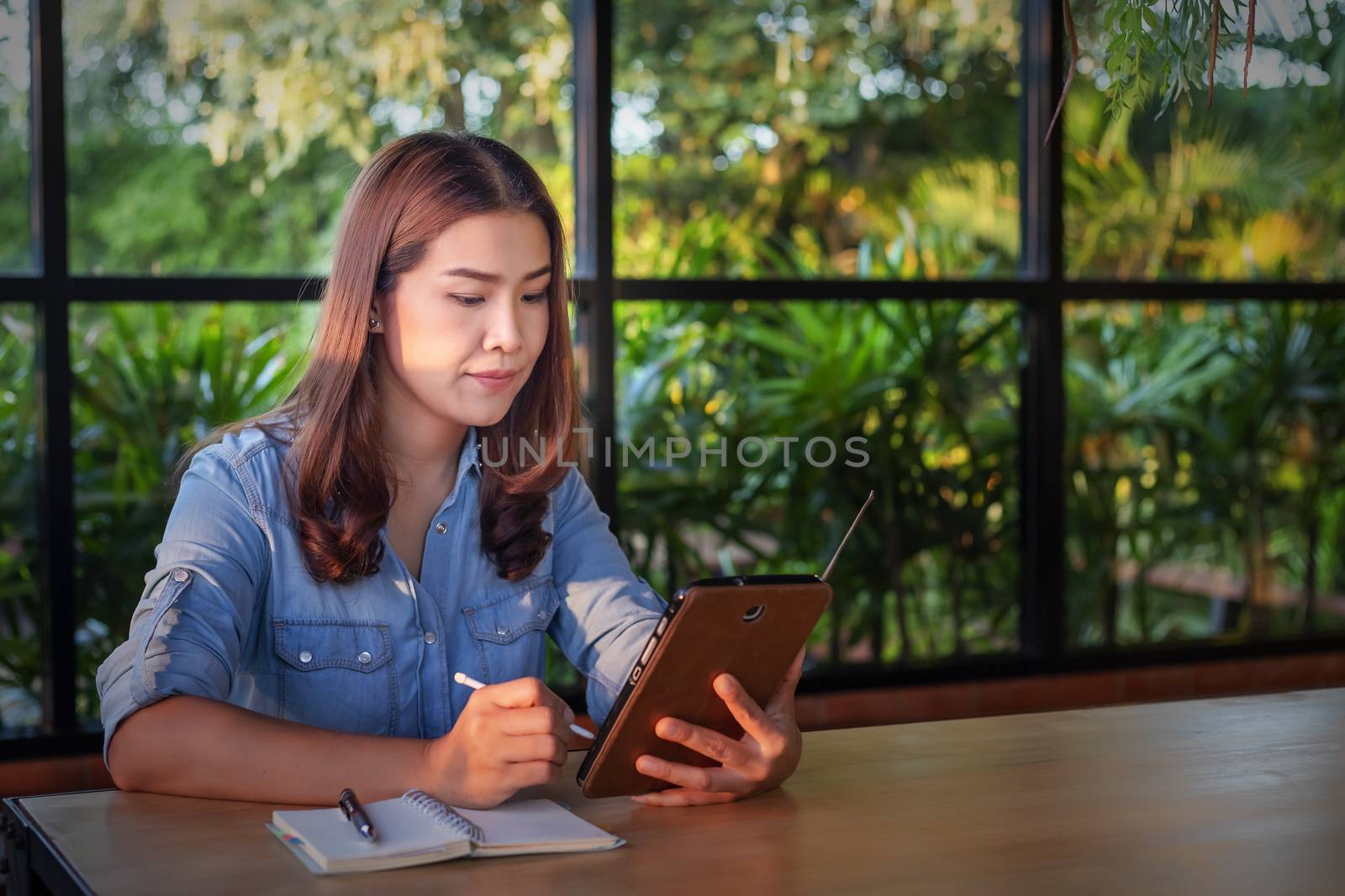 Beautiful Asian businesswoman who uses a tablet in the coffee sh by numberone9018