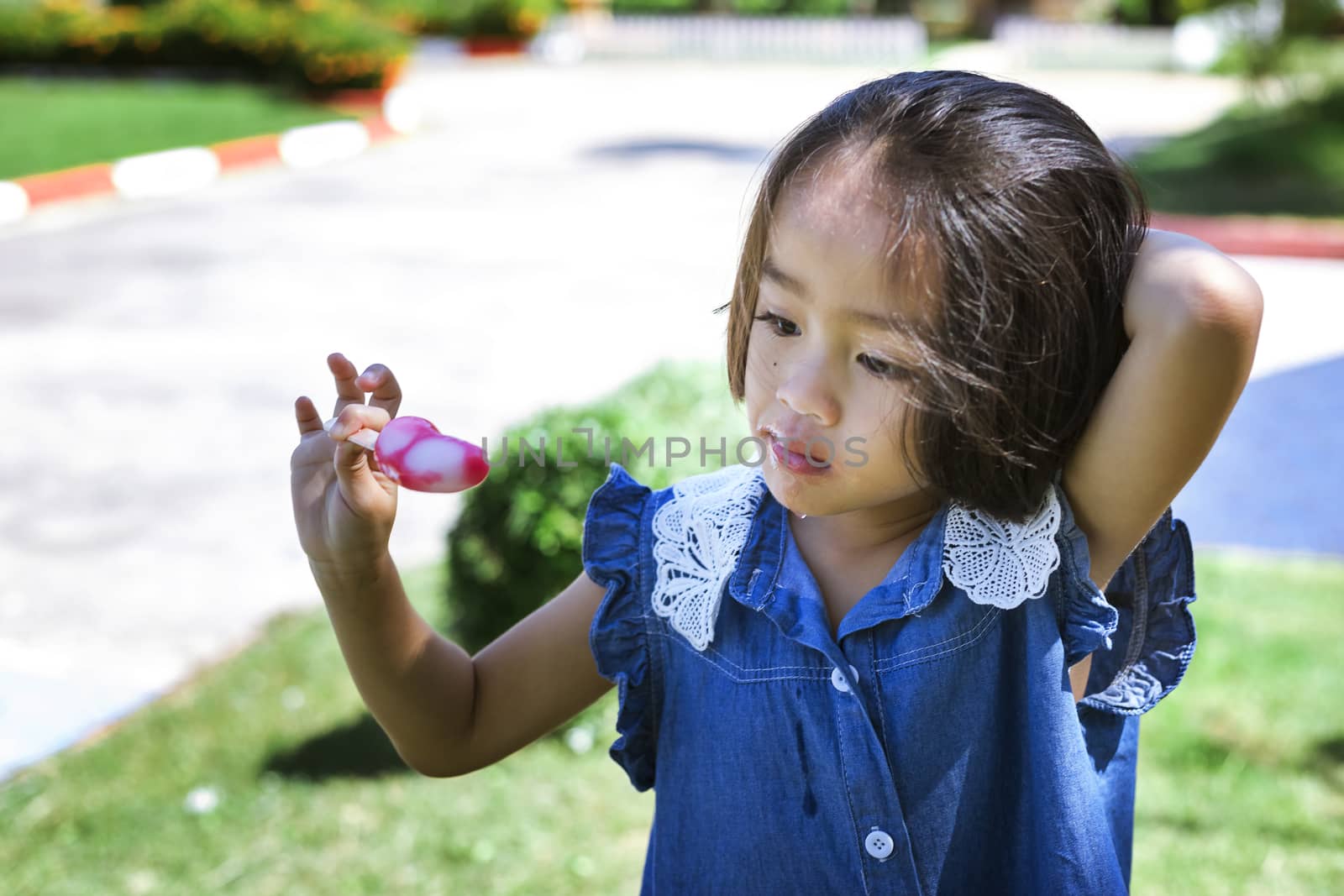 Cute little girl eating popsicle with sunset background by numberone9018