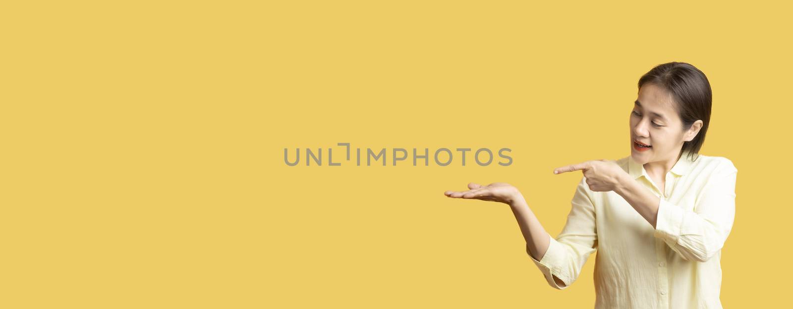 Beatuful asia women's hand Two hands One hand pointing the other hand Open hands on yello background with copy space. Human hand with copy space. for product or advertising .