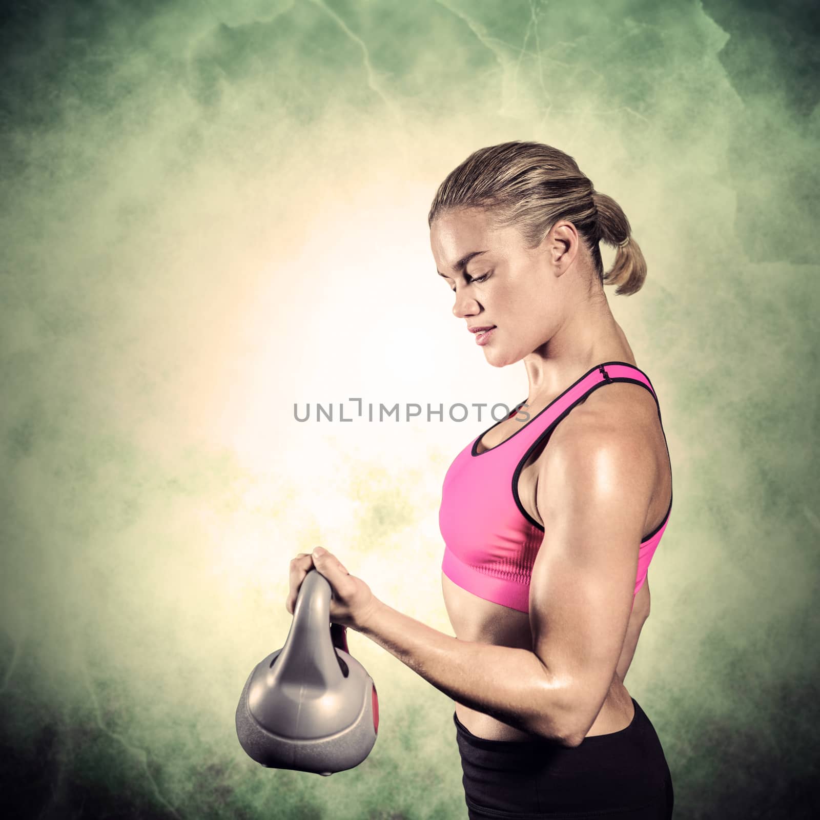 Muscular woman lifting heavy kettlebell against dark background